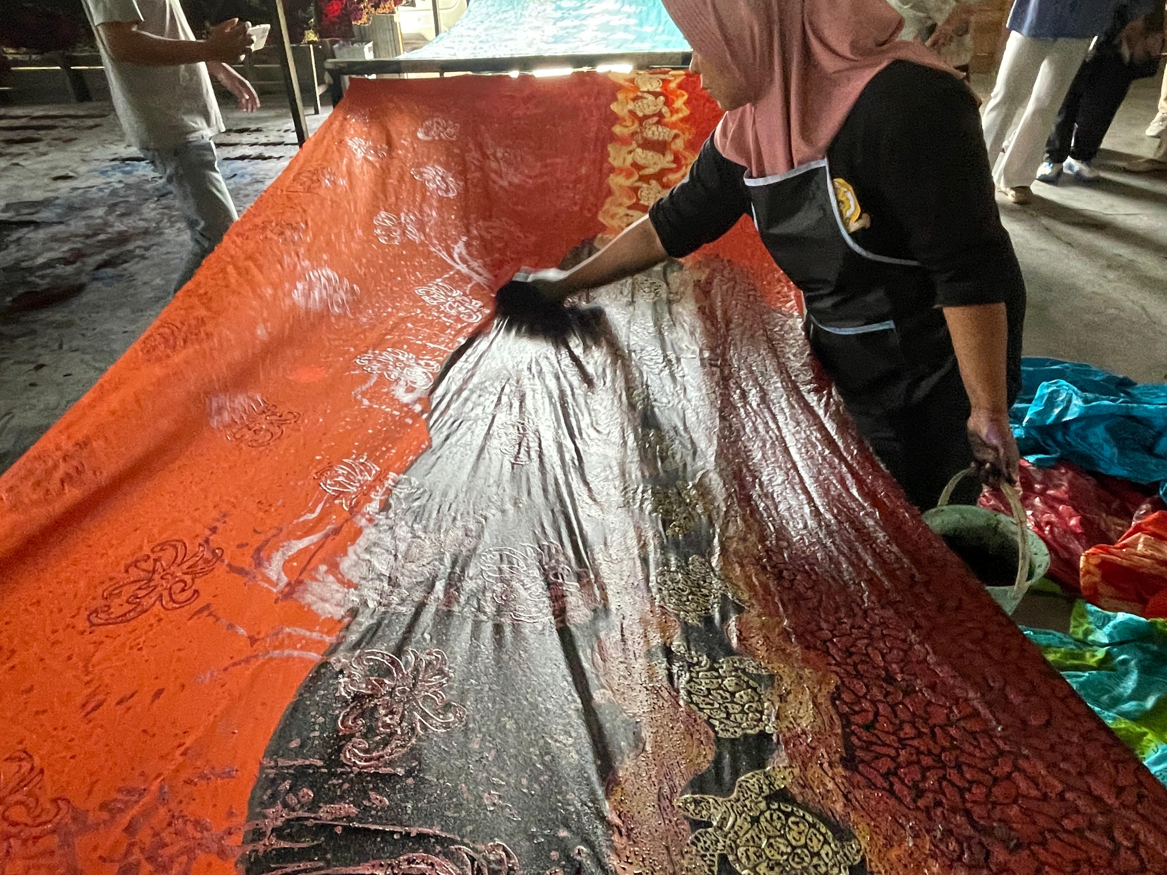 Proses pewarnaan kain batik setelah di cap dan lukis di tempat produksi Putri Maluang Batik.